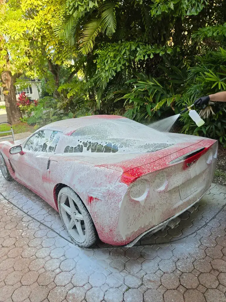 Foam cannon pre-wash on a red Corvette during a mobile full detail